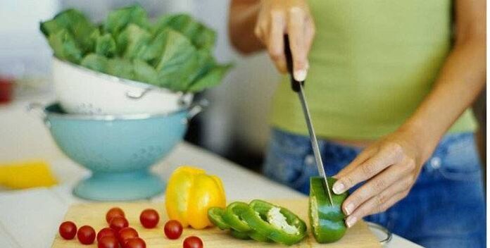 Cociñar unha ensalada de vexetais para a cea segundo os principios dunha nutrición adecuada para unha figura delgada